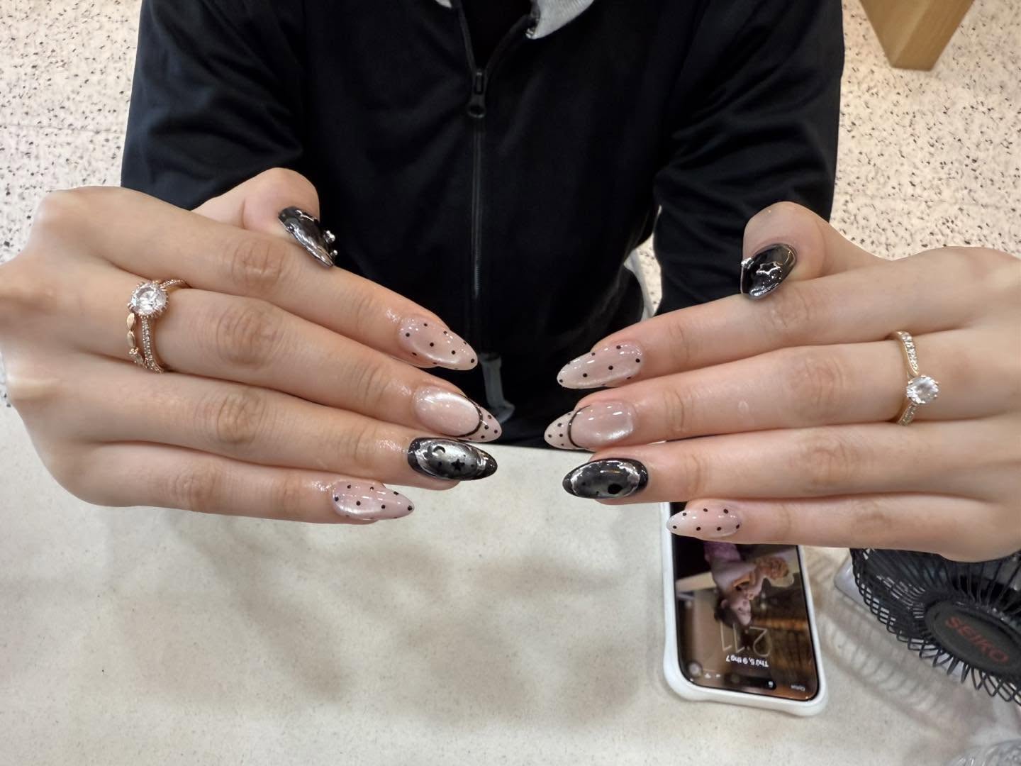 Nude nails with black polka-dot and marbled accent details by Beauty Genesis